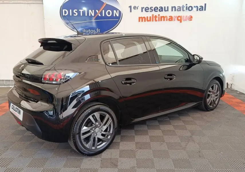 Peugeot 208 PureTech 100 S&S Style noir vue 3/4 arrière droit en intérieur avec jantes alliage et feux LED distinctifs.