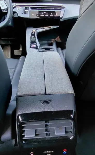 Vue intérieure arrière du Peugeot 5008 Hybrid gris 2025, mettant en valeur la console centrale et les commandes climatisation arrière.