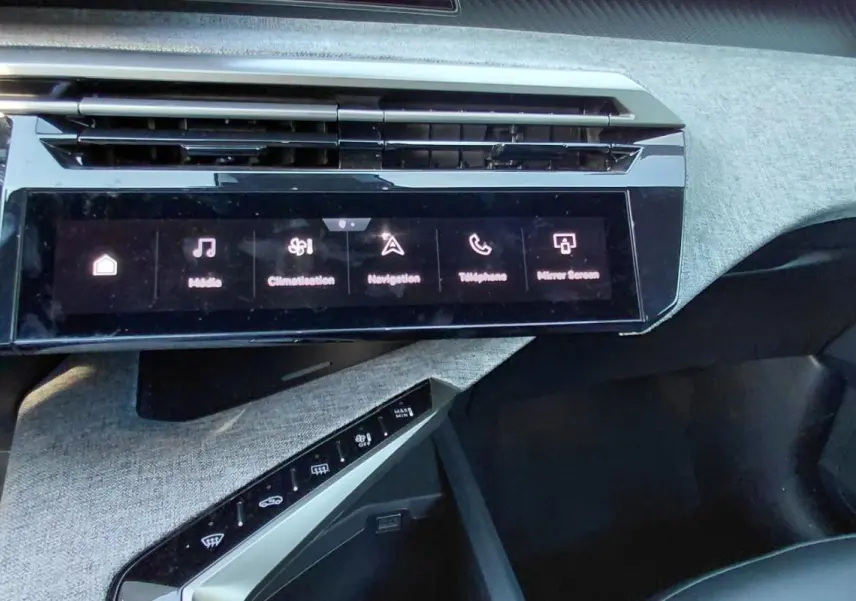 Vue rapprochée de la console centrale du Peugeot 5008 Hybrid 2025, écran tactile et finition tissu gris.