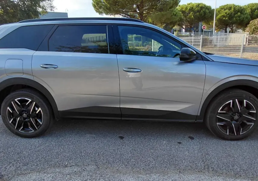 Peugeot 5008 gris vue de profil côté gauche, soulignant ses jantes noires et lignes modernes.