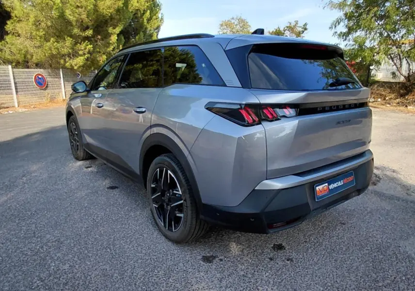 Peugeot 5008 gris en 3/4 arrière droit, mettant en valeur ses feux arrière à griffes et ses jantes noires.
