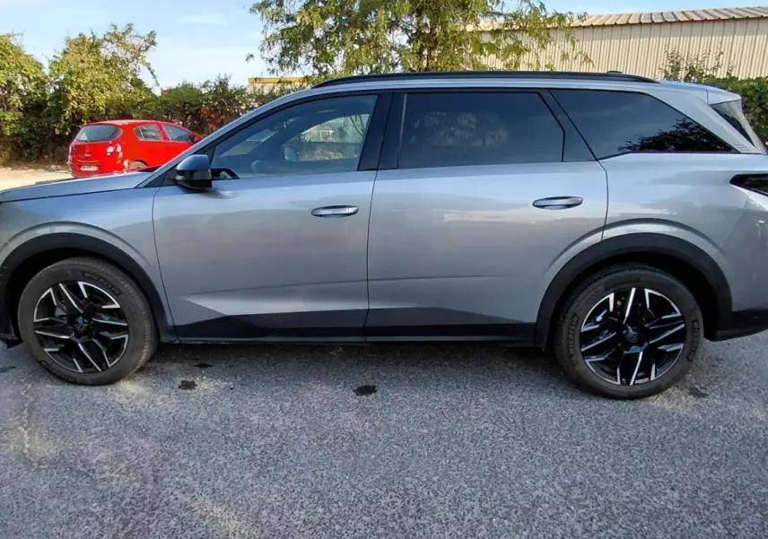 Peugeot 5008 Hybrid gris vue de profil côté gauche, soulignant ses jantes noires et lignes modernes.