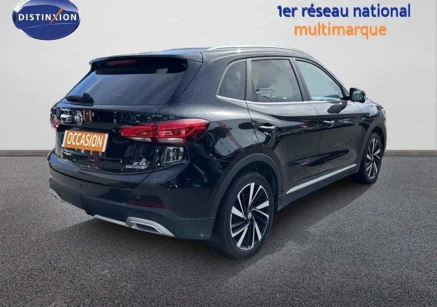 Vue 3/4 arrière droite du MG ZS 1.5L HYBRID+ 197CH Luxury noir Pebble Black Metal avec jantes alliage bicolores.