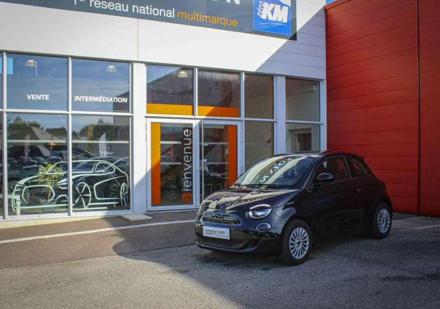 Fiat 500 électrique noire vue en 3/4 avant droit, avec jantes alliage et détails chromés sur calandre.
