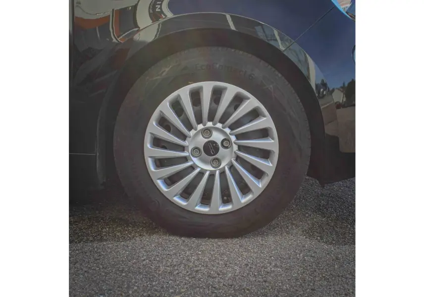 Gros plan sur la roue arrière droite de la Fiat 500 électrique noire avec jante alliage 16 pouces Icône.