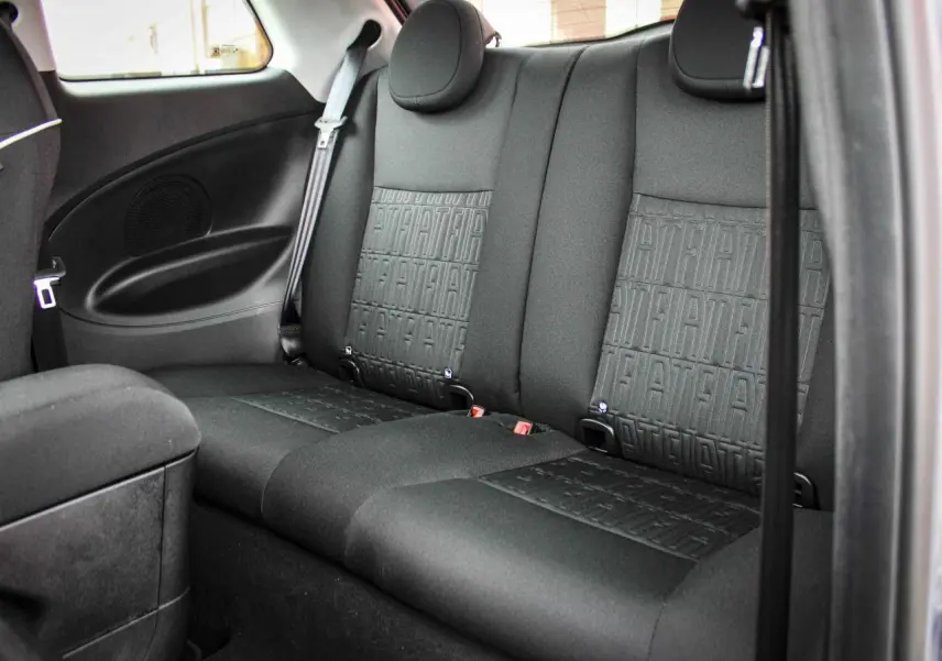 Vue intérieure arrière montrant les sièges arrière noirs avec motif FIAT en tissu dans une Fiat 500 électrique 2023.