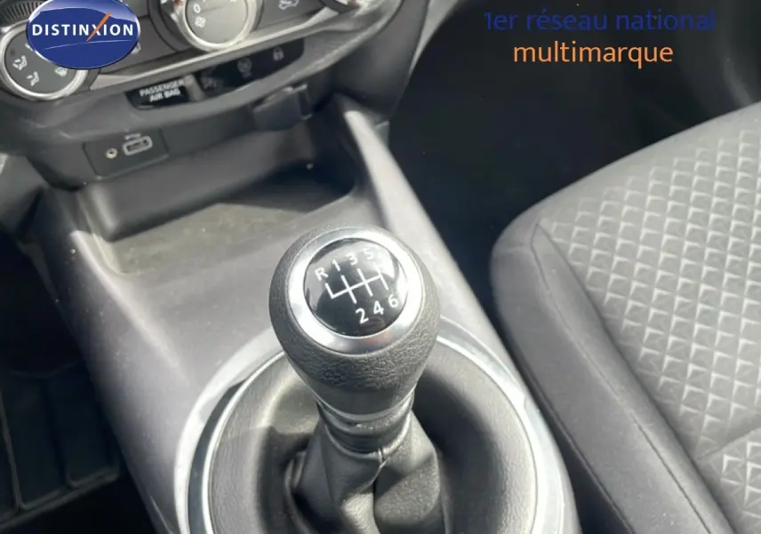 Gros plan sur le levier de vitesse manuel noir dans l'habitacle gris foncé du Nissan Juke 2023.