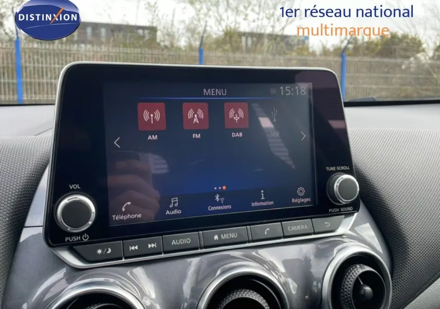 Vue rapprochée de l’écran tactile central du Nissan Juke 2023 noir perle métal, affichant le menu radio et les commandes audio.
