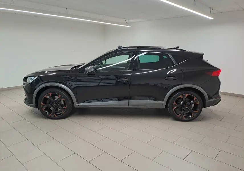 Vue de profil côté gauche du CUPRA Formentor 1.4 e-HYBRID noir minuit avec jantes noires et détails cuivre en intérieur.
