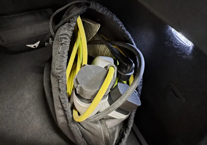 Gros plan sur le câble de recharge jaune et noir dans le coffre sombre d'une CUPRA Formentor 1.4 e-HYBRID 2023.