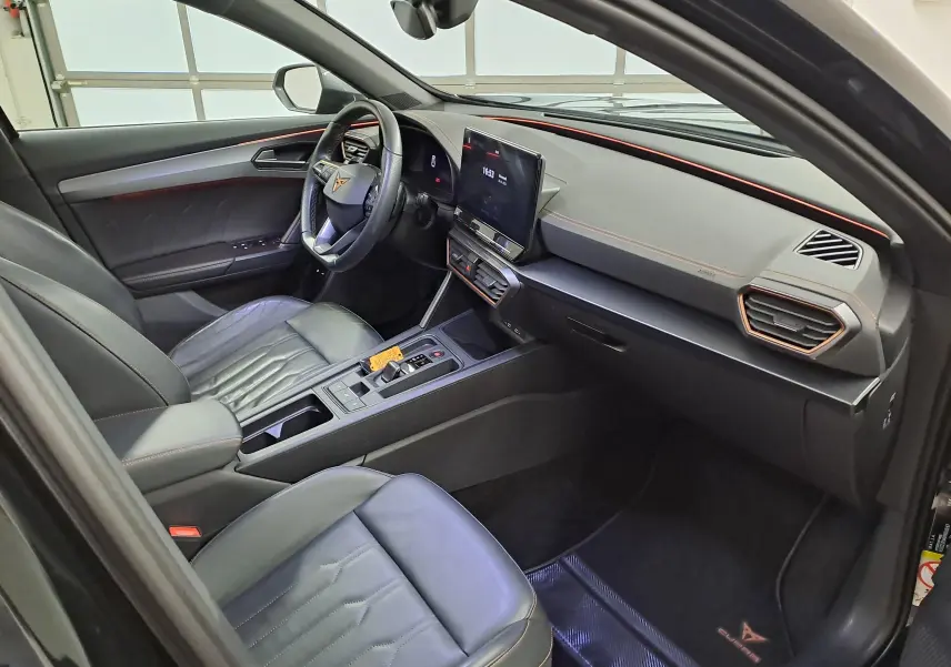 Vue intérieure côté conducteur du CUPRA Formentor 1.4 e-HYBRID 2023 avec cuir noir, surpiqûres cuivre et tableau de bord moderne.