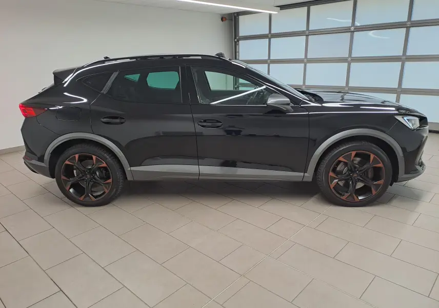 Profil droit du CUPRA Formentor 1.4 e-HYBRID 2023 en noir minuit avec jantes 19'' noires et cuivre, toit ouvrant panoramique visible.