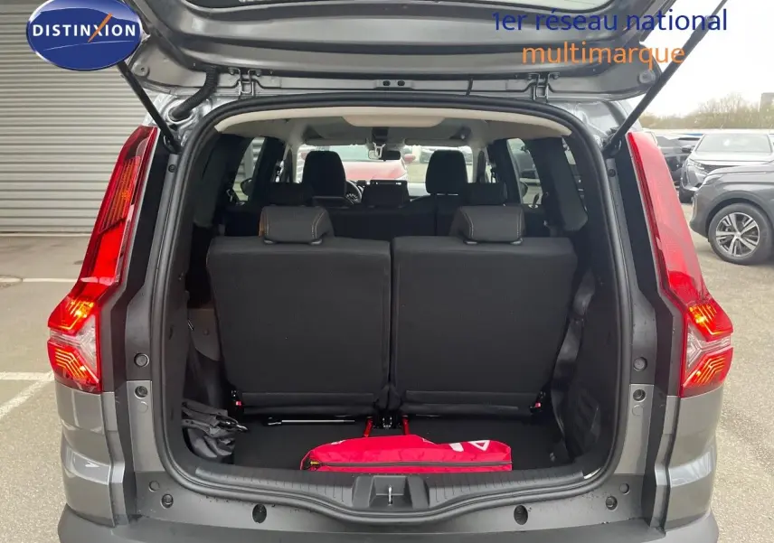 Vue arrière ouverte du Dacia Jogger gris schiste métal, montrant le coffre et les sièges arrière noirs.