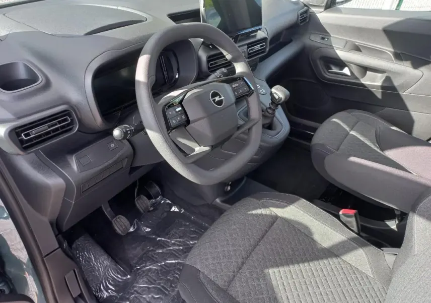 Intérieur de l’Opel Combo Life Elegance M 2025, vue côté conducteur, tableau de bord noir et sièges gris foncé.