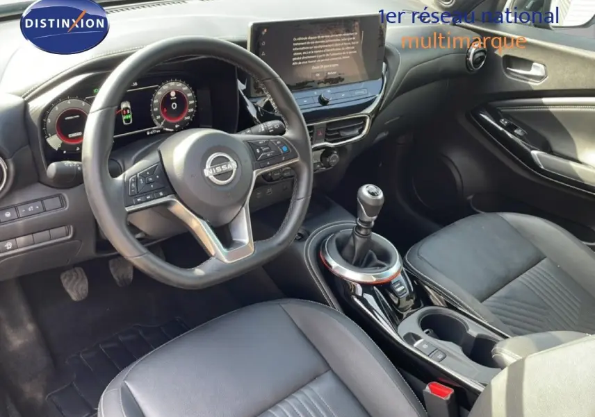 Vue intérieure de la Nissan Juke 2025 DIG-T Tekna, volant cuir, tableau de bord digital et levier de vitesse manuel.