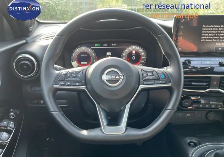 Vue intérieure centrée sur le volant cuir du Nissan Juke 2025 noir Kuro Metal avec tableau de bord digital et écran tactile.