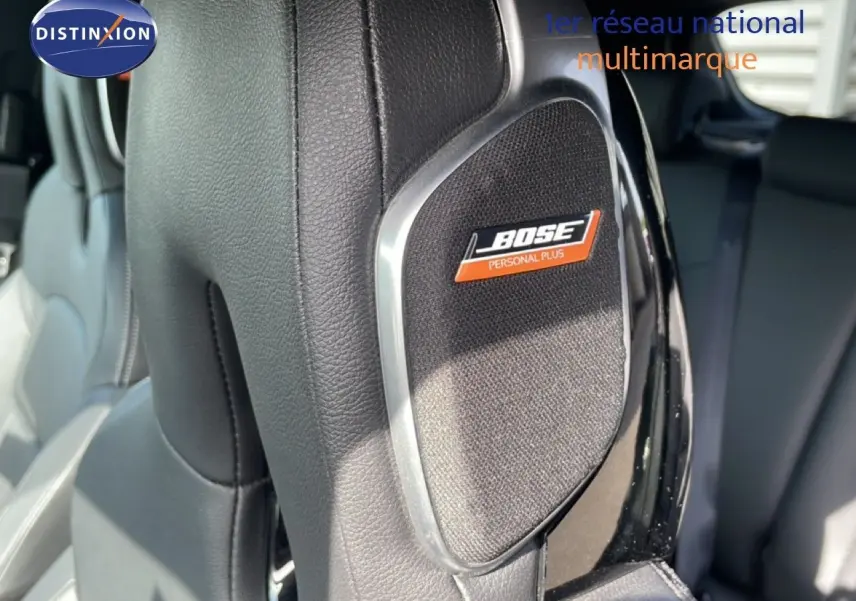 Gros plan sur l’enceinte Bose intégrée au dossier en cuir noir du siège avant d’un Nissan Juke 2025.
