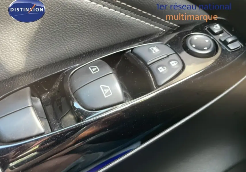 Gros plan sur les commandes des vitres et rétroviseurs côté conducteur du Nissan Juke noir Kuro Metal 2025.