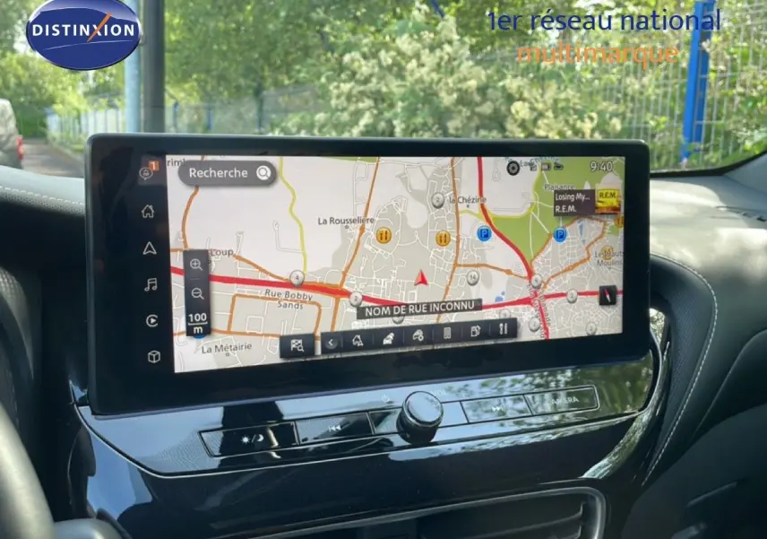Vue intérieure du tableau de bord du Nissan Juke 2025 noir Kuro Metal, avec écran tactile affichant la navigation GPS.