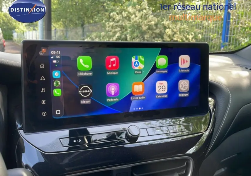Vue intérieure centrée sur l'écran tactile du tableau de bord du Nissan Juke 2025 noir, affichant les applications connectées.