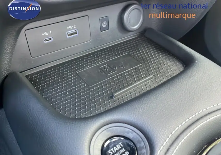 Gros plan sur la console centrale du Nissan Juke noir Kuro Metal, montrant le bouton start/stop et les ports USB.