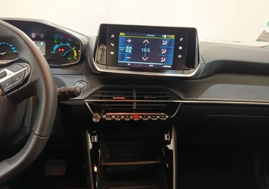 Vue intérieure du tableau de bord de la Peugeot E-2008 électrique Active Pack 2023 avec écran tactile et volant cuir noir.