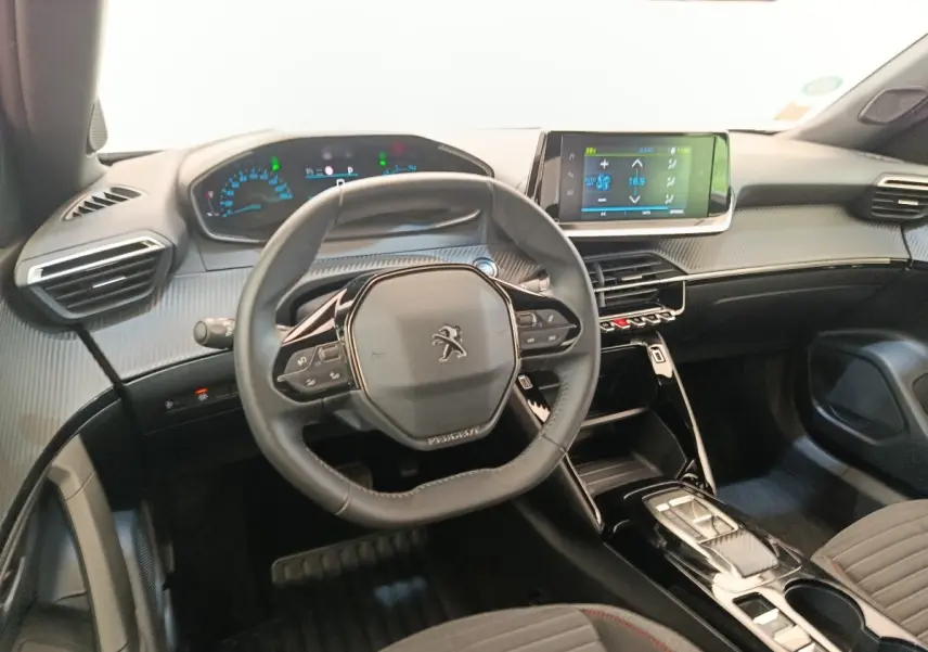 Intérieur du Peugeot E-2008 électrique 2023, vue du poste de conduite avec volant cuir multifonctions et écran tactile central.