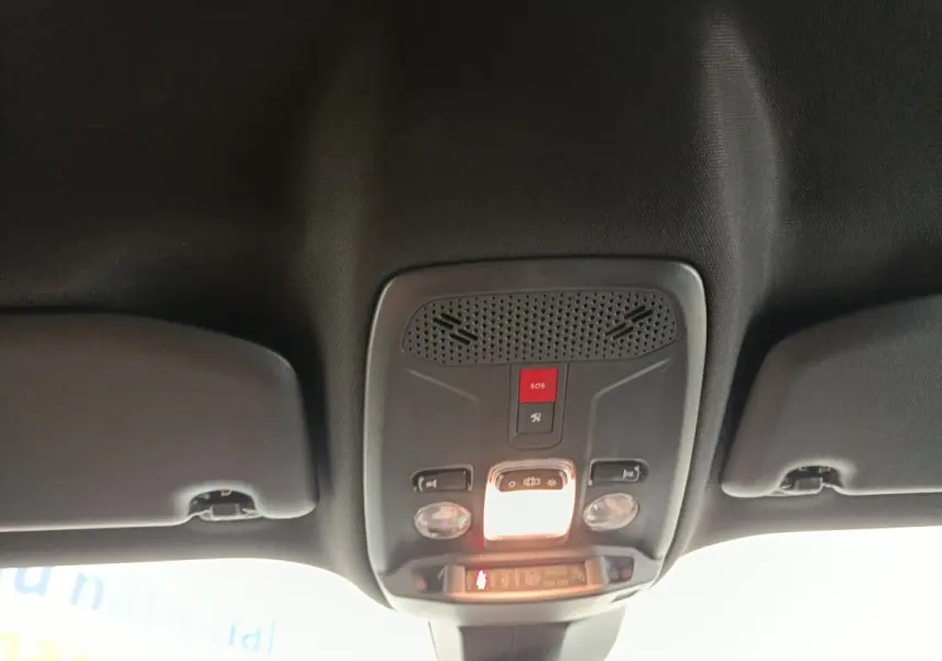 Plafonnier intérieur avec commandes d’éclairage et bouton SOS du Peugeot E-2008 électrique gris clair, vue de dessous.
