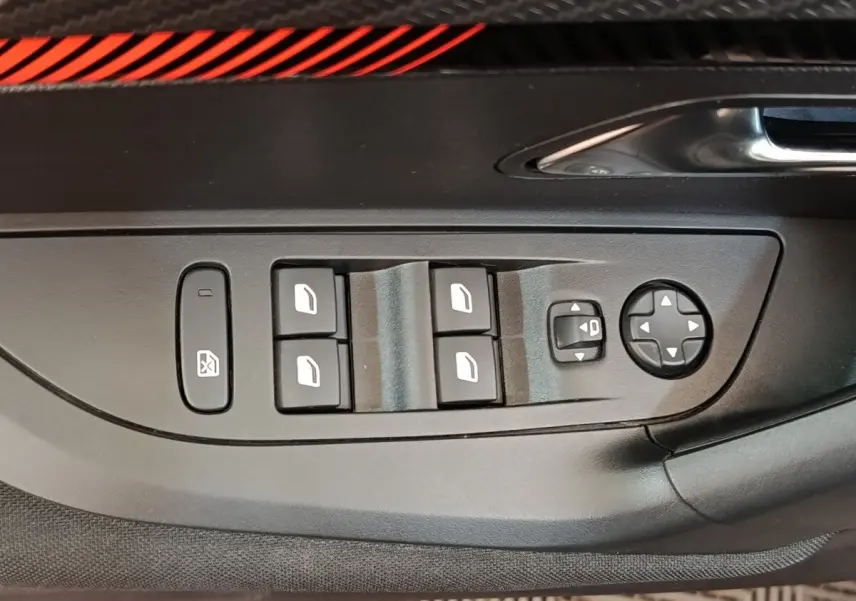 Gros plan sur les commandes de lève-vitres et rétroviseurs électriques côté conducteur du Peugeot E-2008 gris clair.