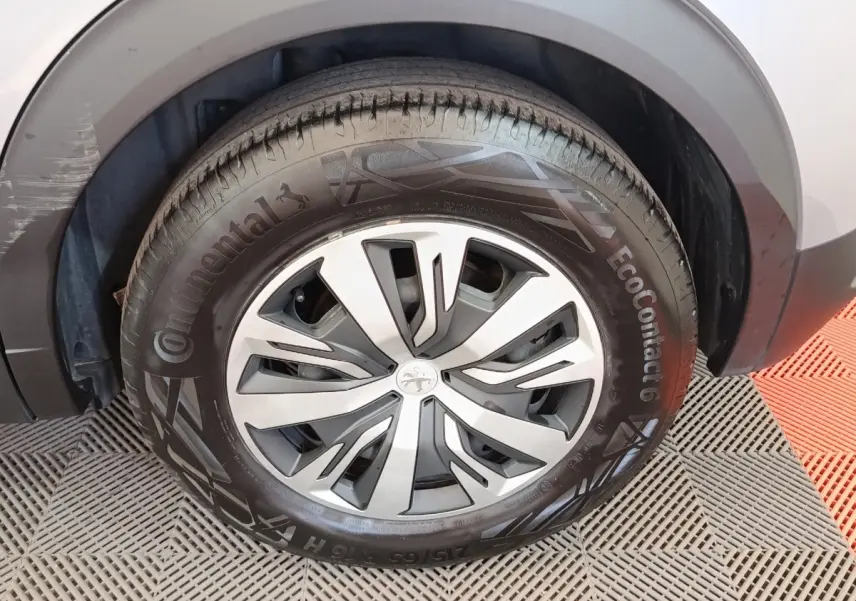 Gros plan sur la roue avant droite gris clair du Peugeot E-2008 électrique avec jante spécifique et pneu Continental.