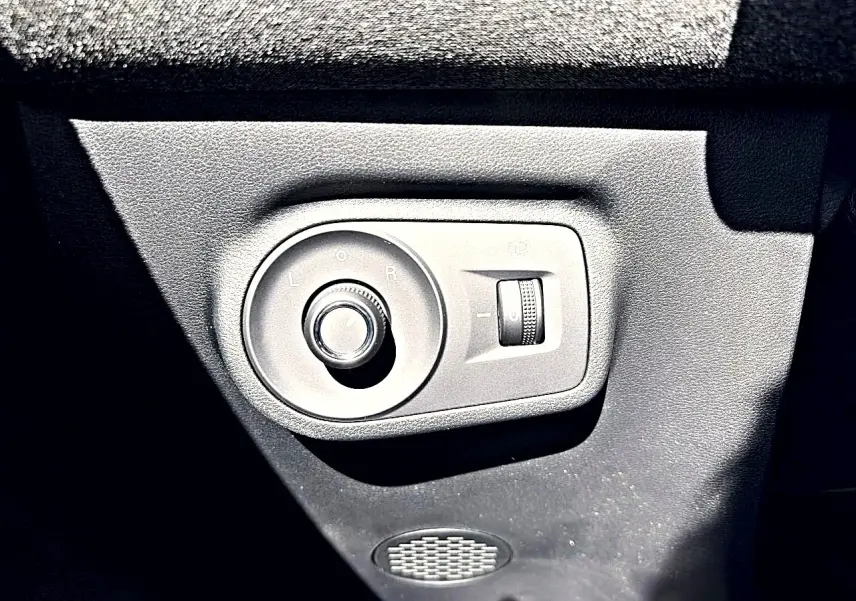 Gros plan sur la commande de réglage des rétroviseurs côté conducteur du MG Motor ZS noir hybride 2026.