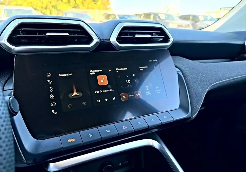 Vue rapprochée de la console centrale du MG Motor ZS hybride 2026, écran tactile et aérateurs hexagonaux noirs.