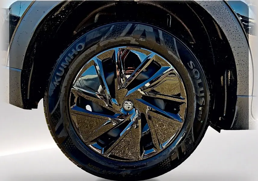 Gros plan sur la roue avant droite du MG ZS noir, mettant en valeur la jante brillante au design moderne.