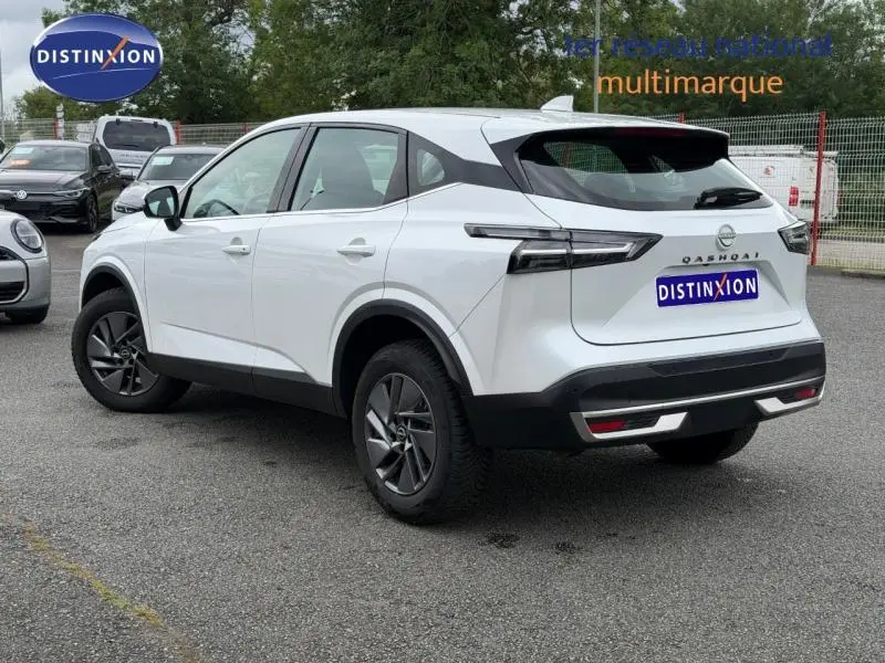 Nissan Qashqai blanc nacré vu en 3/4 arrière droit, avec jantes alu et feux arrière LED distinctifs.