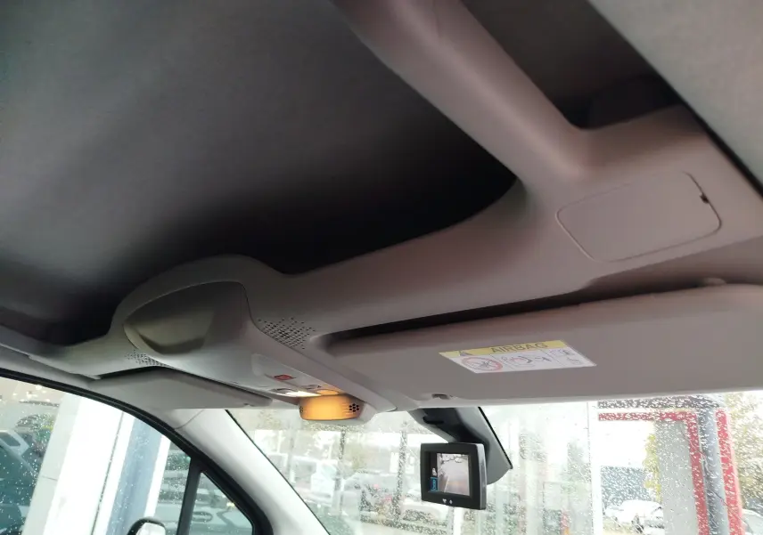 Vue intérieure du plafond et pare-soleil côté conducteur d’un Peugeot Partner gris foncé 2020 avec caméra de recul affichée.