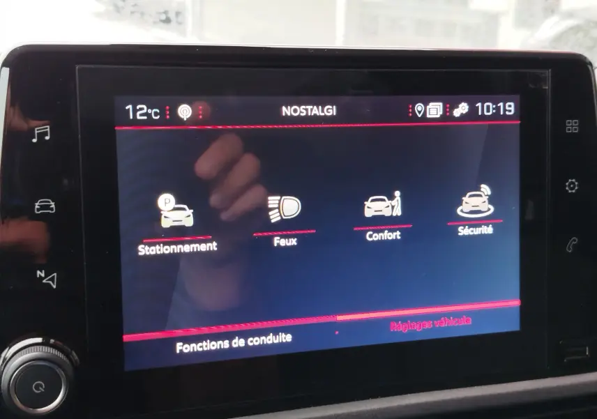 Écran tactile intérieur du Peugeot Partner 2020 montrant les options de conduite avec icônes pour stationnement, feux, confort et sécurité.