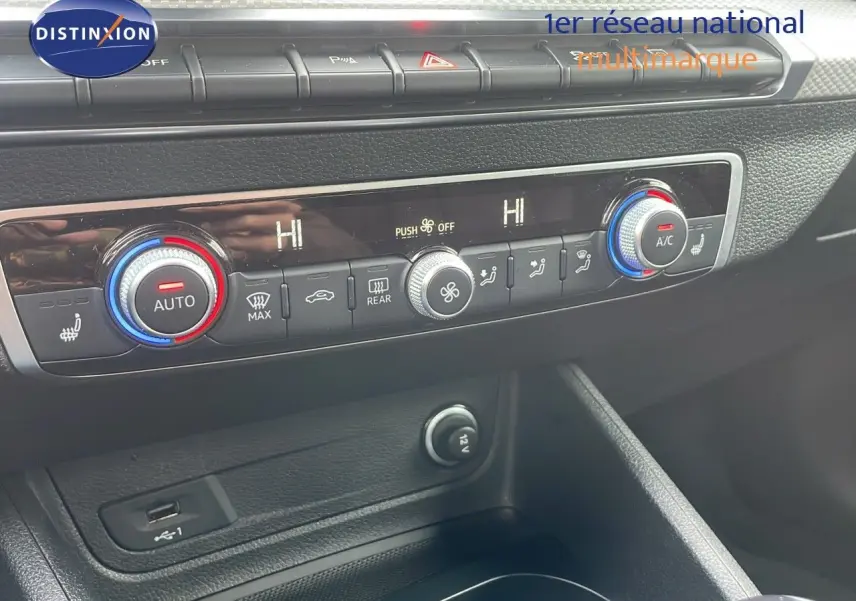 Détail de la console centrale avec commandes de climatisation et prise USB de l'Audi Q2 noir mito metal 2023.