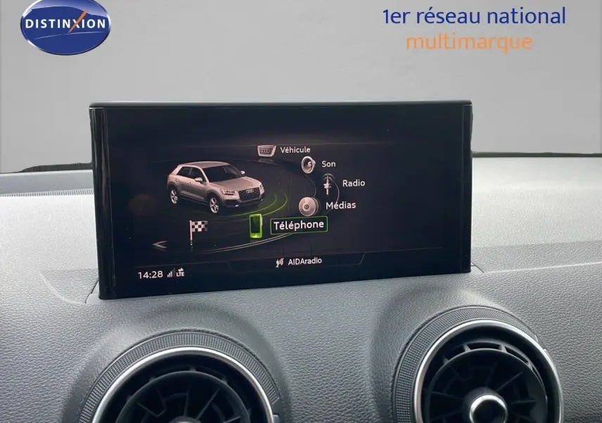 Écran central affichant le menu multimédia de l'Audi Q2 35 TFSI 2023, tableau de bord gris clair.