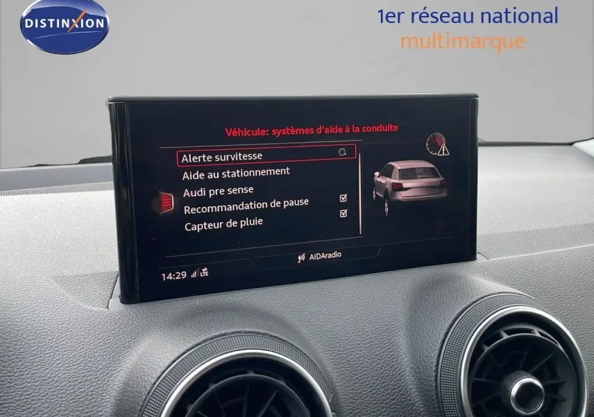 Écran central affichant les aides à la conduite de l'Audi Q2 35 TFSI noir mito metal, vue intérieure du tableau de bord.
