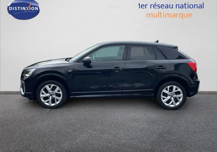 Profil côté gauche d'un Audi Q2 noir mito metal 2023, finition S-Line avec jantes alliage et lignes épurées.