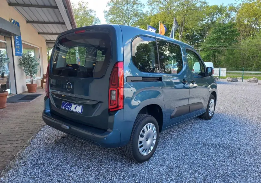 Opel Combo Life bleu en 3/4 arrière droit, avec vitres teintées et porte latérale coulissante visible.