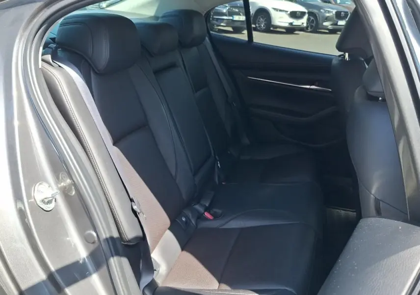 Vue intérieure montrant les sièges arrière en cuir noir d'une Mazda3 gris 2020, porte arrière ouverte côté gauche.