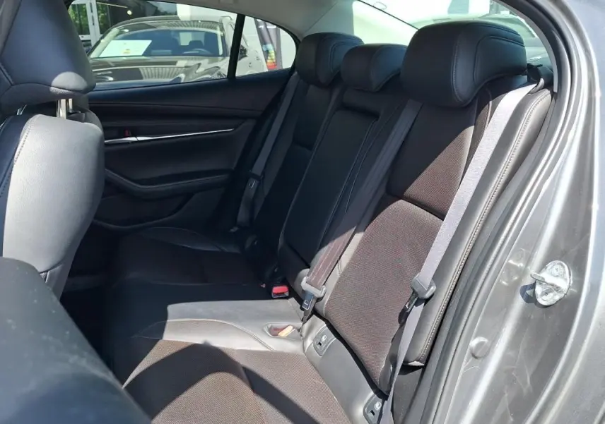 Vue intérieure côté droit des sièges arrière en cuir noir d'une Mazda3 gris 2020, avec ceinture de sécurité visible.