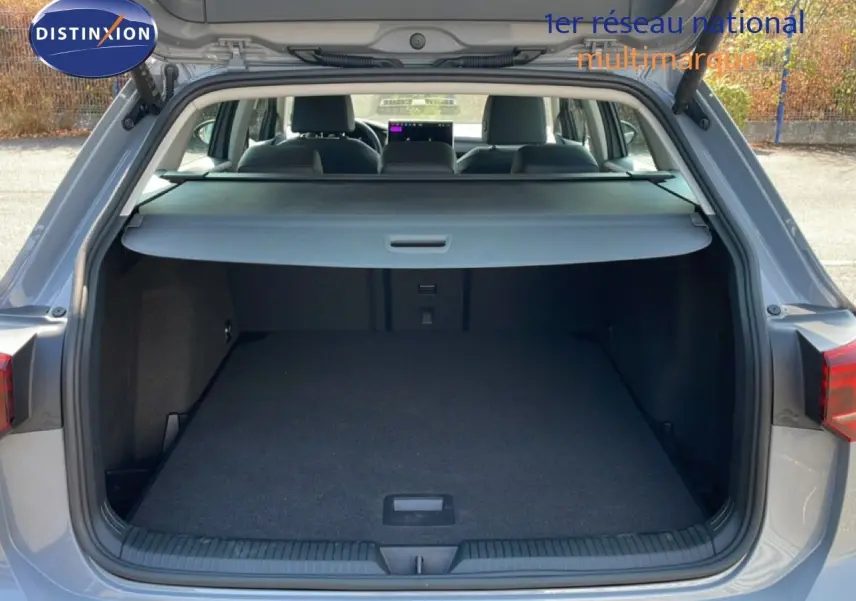 Coffre ouvert d'une Volkswagen Golf SW gris lunaire métal, vue arrière montrant l'espace de chargement et la plage arrière.