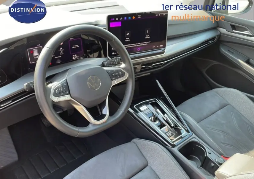 Vue intérieure côté conducteur de la Volkswagen Golf SW VIII 2024, tableau de bord moderne avec écran tactile et volant cuir gris.