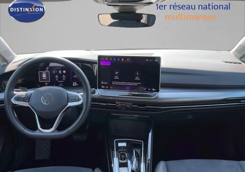 Vue intérieure frontale du tableau de bord et volant gris d'une Volkswagen Golf SW VIII 2024 avec écran tactile central.