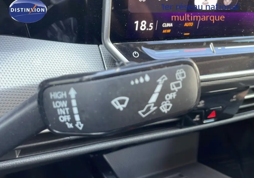 Gros plan sur la commande d’essuie-glace dans l’habitacle gris noir d’une Volkswagen Golf SW VIII 2024, tableau de bord en arrière-plan.
