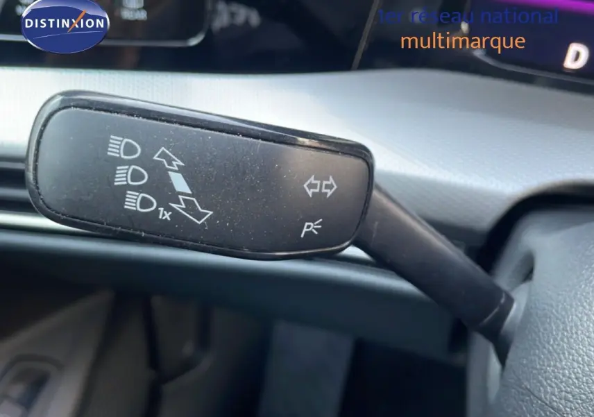 Gros plan sur la commande de clignotant à gauche du volant d'une Volkswagen Golf SW VIII gris lunaire 2024.