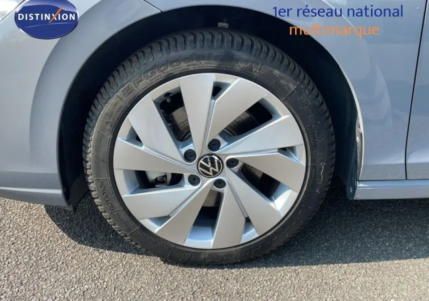 Gros plan sur la roue avant droite d'une Volkswagen Golf SW gris lunaire métal avec jante alu distinctive.