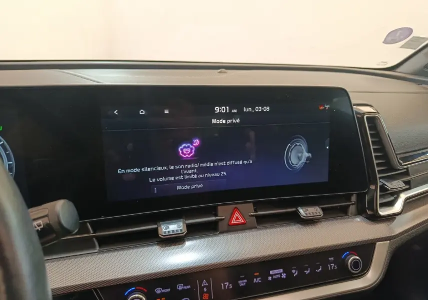 Vue rapprochée du tableau de bord du Kia Sportage gris clair 2022, avec écran tactile central allumé en mode privé.